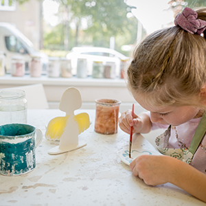 Little girl painting inside of an art studio.