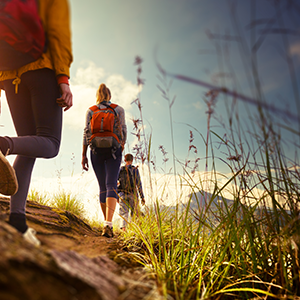 Group of people hiking on a trail outdoors.