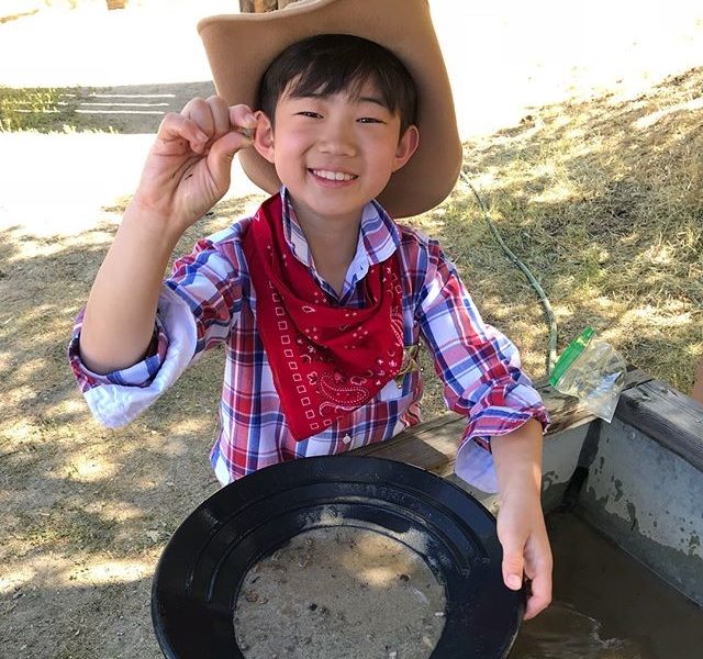Boy panning for gold outside at the Cowboy Festival in Santa Clarita.