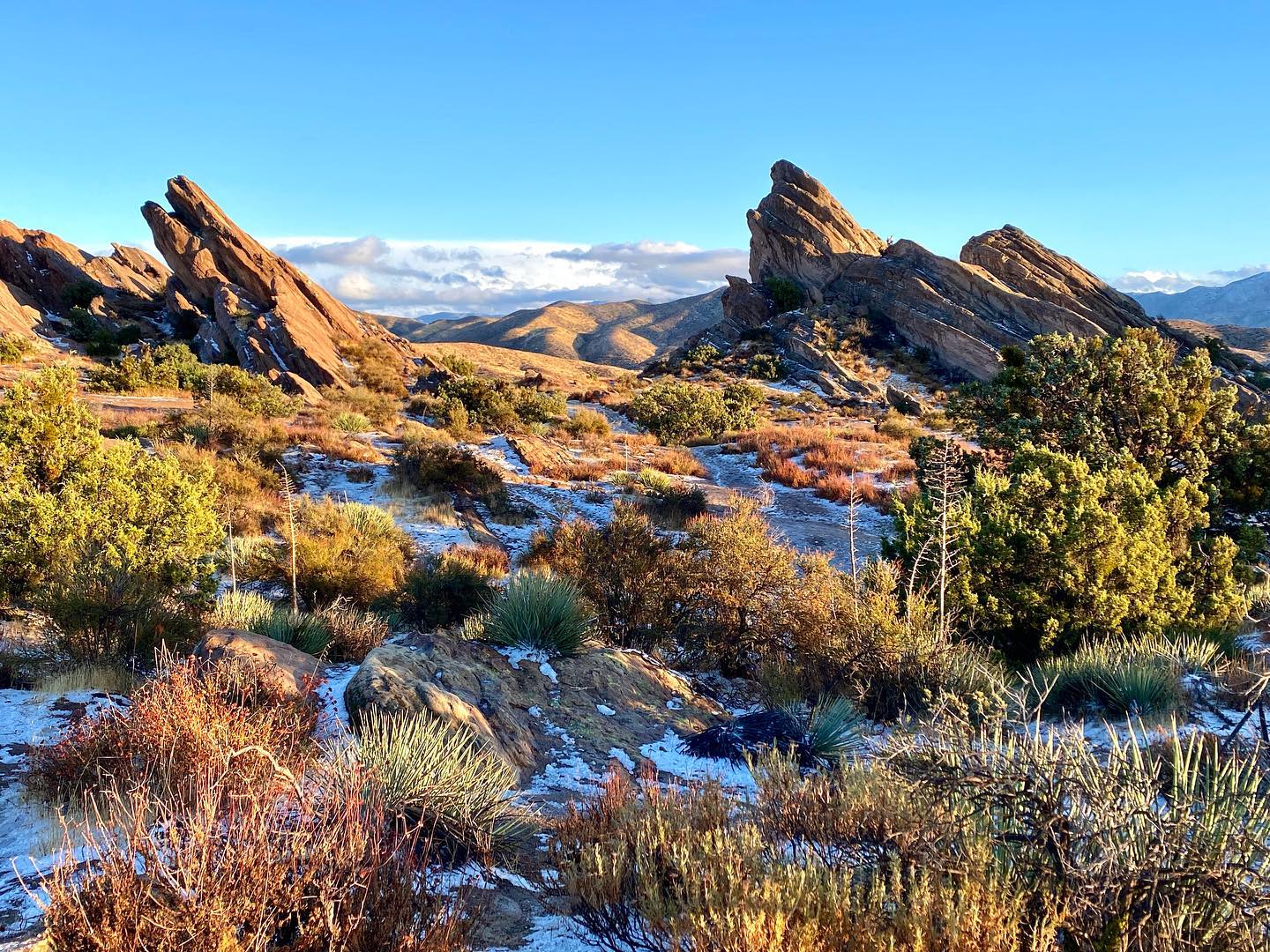 Trail in Santa Clarita with snow on the ground and large rocks in the background.